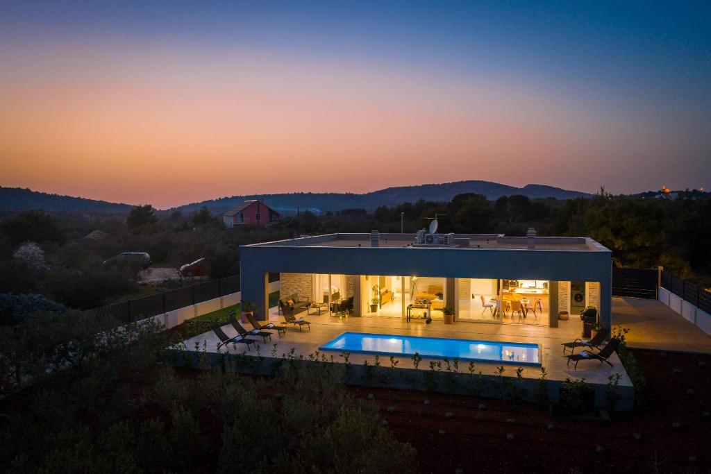 a house with a swimming pool at sunset at Villa Millennium in Jezera