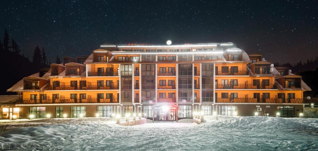 a large building in the snow at night at Apartment in Snow Plaza 49 in Bakuriani