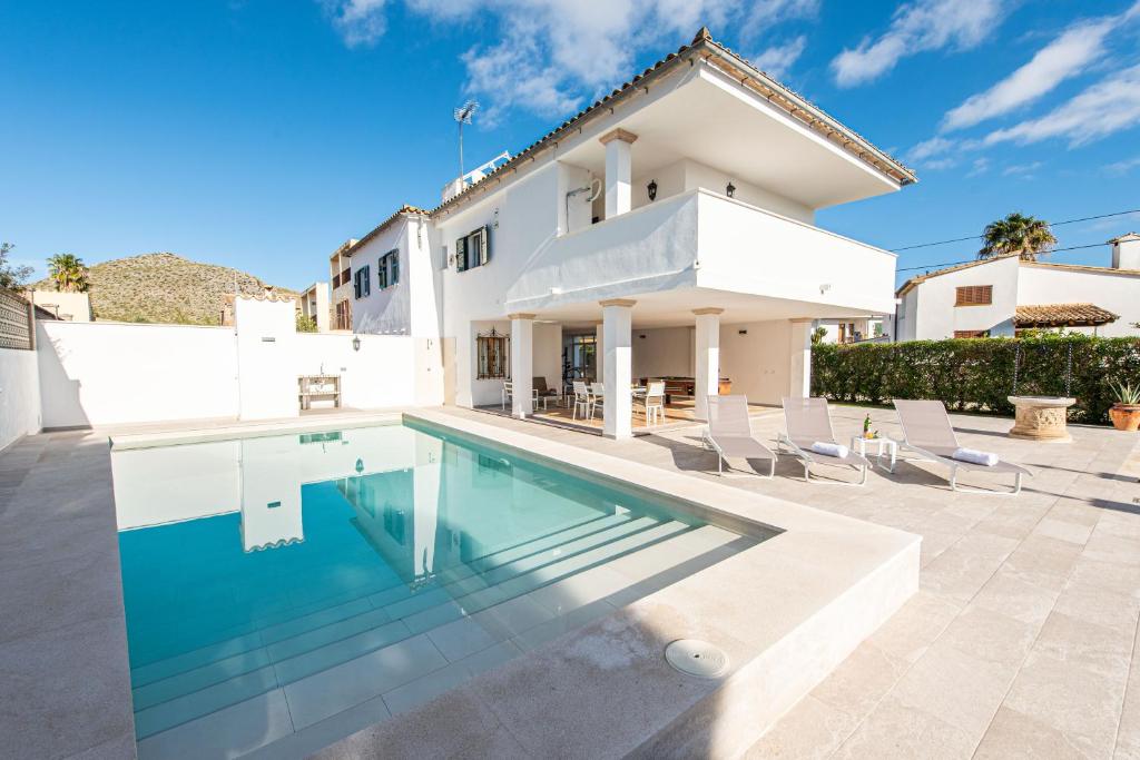 una villa con piscina e una casa di A perfect location villa for holidays with AC and private pool a Port de Pollença