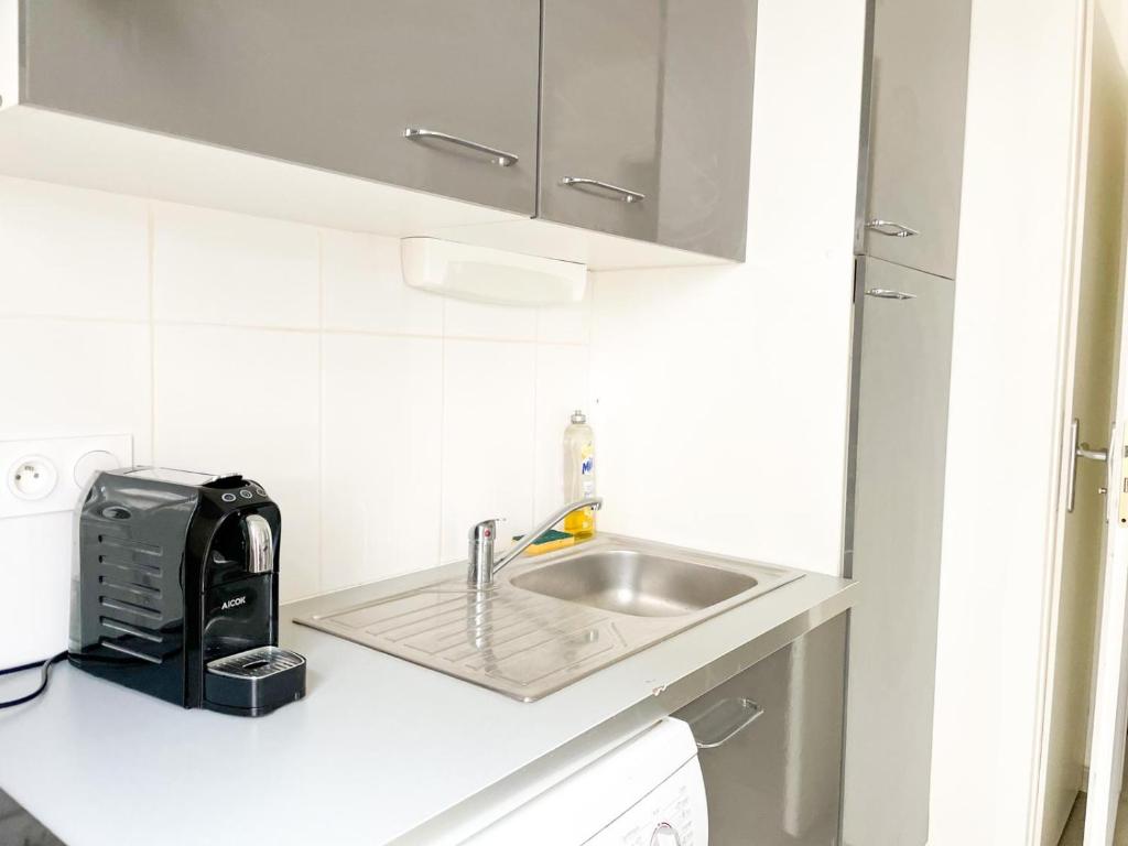 a white kitchen with a sink and a toaster at 003 - Appartement Moderne et Terrasse - Jeanne d&#39;Arc, Toulouse in Toulouse