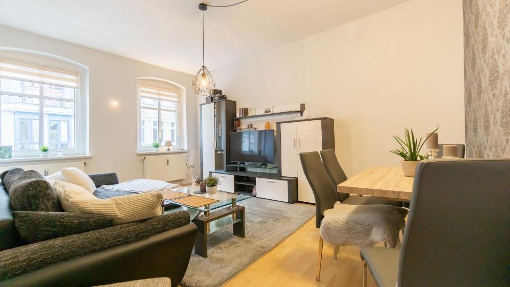 ein Wohnzimmer mit einem Sofa und einem Tisch in der Unterkunft *Central_50m2_Kitchen_Washer_Netflix_Parking in Cottbus