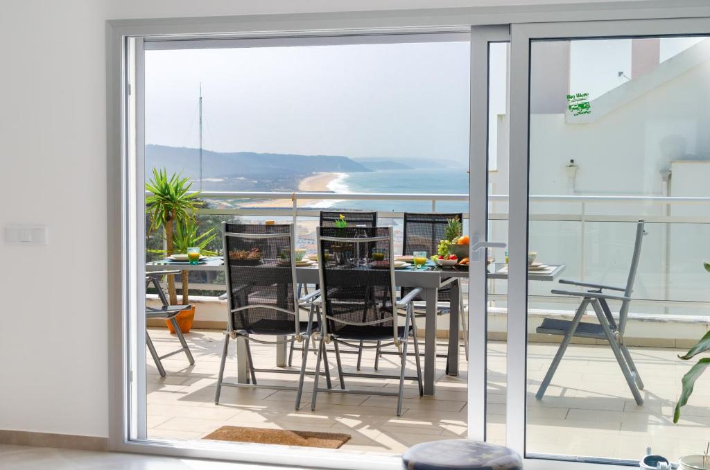 een balkon met uitzicht op een tafel en stoelen bij Sky Terrace - Sea Views & BBQ by Silver Prop in Nazaré