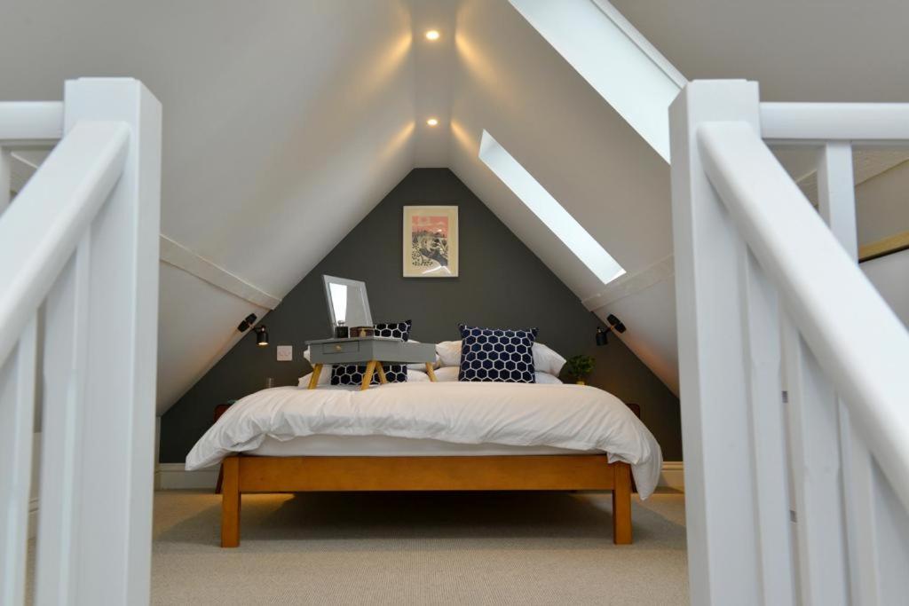 ein Schlafzimmer mit einem Bett im Dachgeschoss in der Unterkunft Nest House Super cosy one bedroom detached lodge center Huntingdon in Huntingdon