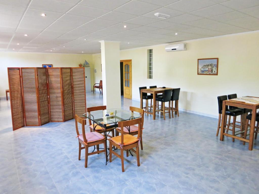 a dining room with a glass table and chairs at Hostal Brisamar in San José