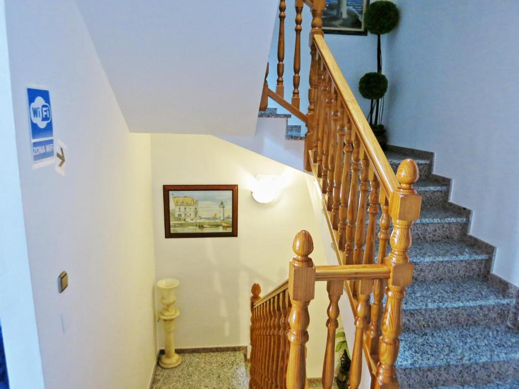 a stairway with a wooden railing and a stair case at Hostal Brisamar in San José