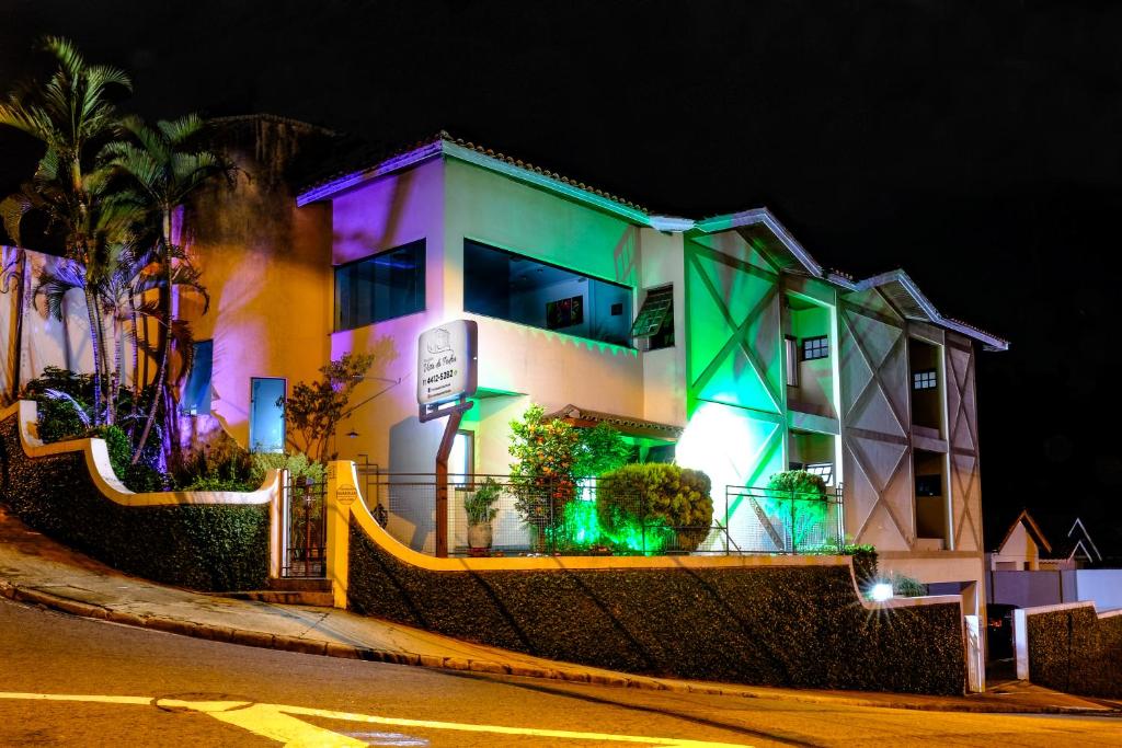 a building with green and purple lights on it at Pousada Vista da Pedra Atibaia in Atibaia