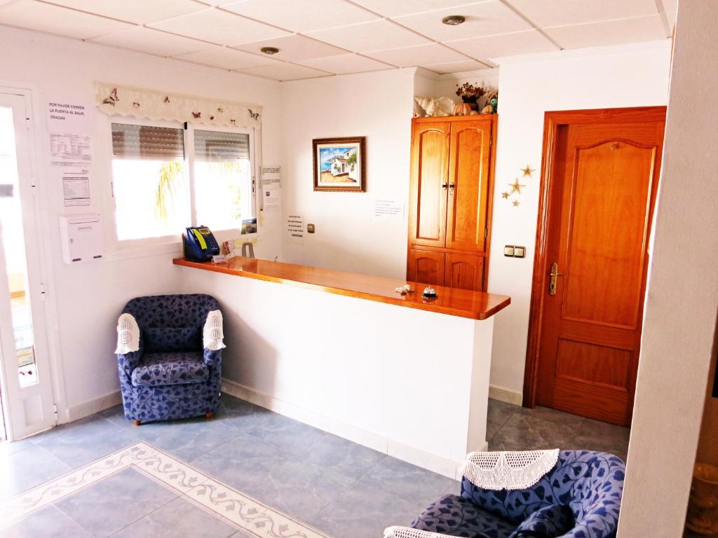 a kitchen with a counter and two chairs in a room at Hostal Brisamar in San José