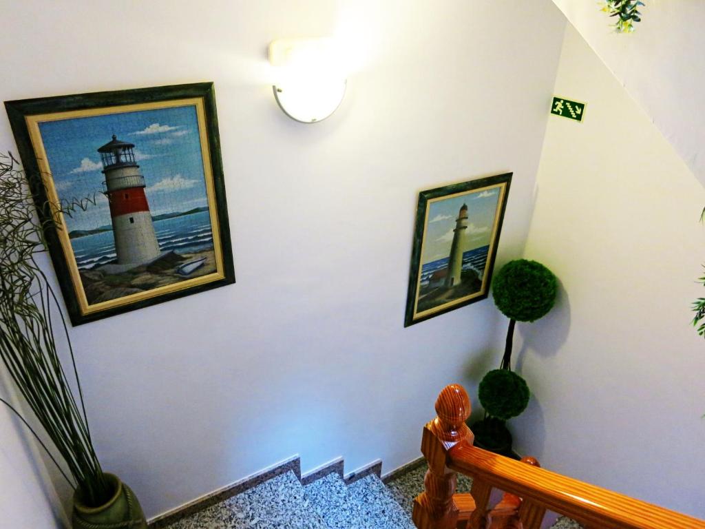 a staircase with two pictures of a lighthouse on the wall at Hostal Brisamar in San José