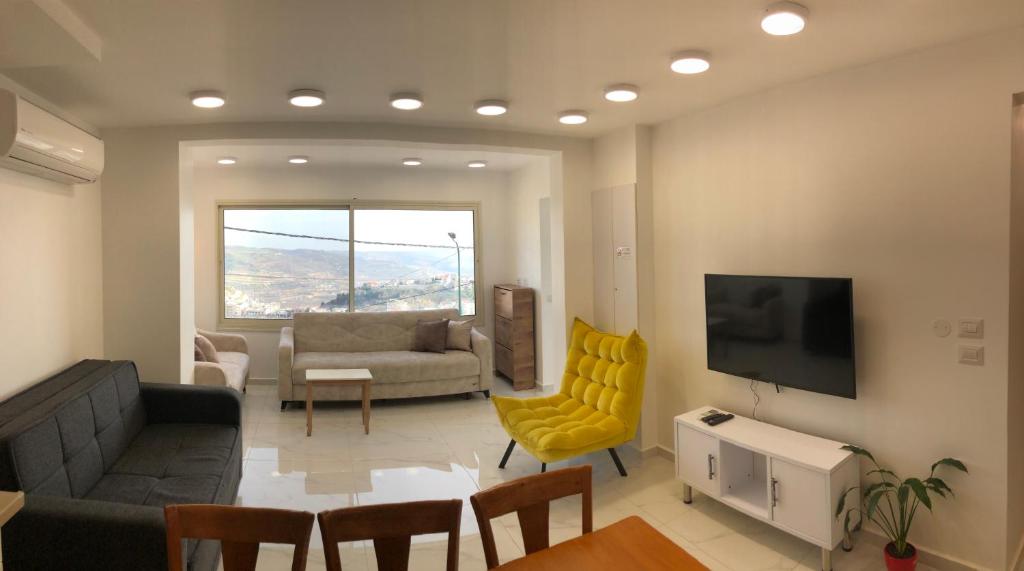 uma sala de estar com um sofá e uma mesa em SleepWell Suite em Majdal Shams