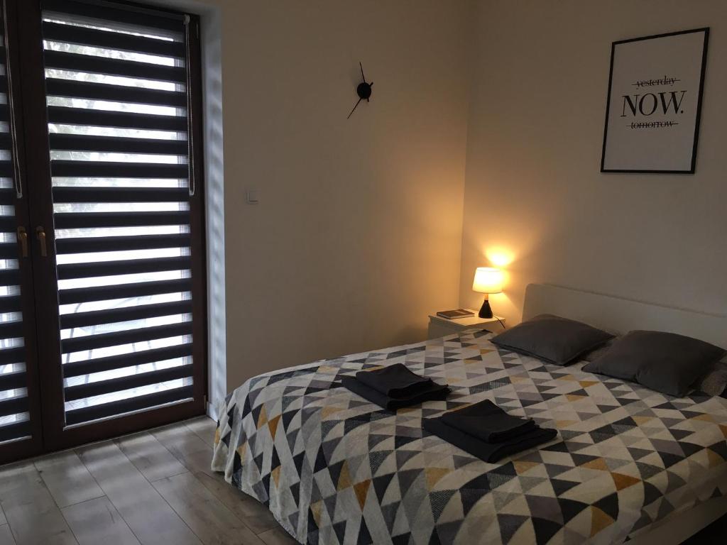 1 dormitorio con 1 cama con manta a cuadros en Studio Fibra Macchiato en Rybnik