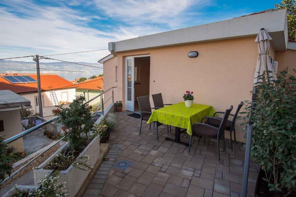 a patio with a green table and chairs on it at Apartment in Vrbnik/Insel Krk 36770 in Vrbnik