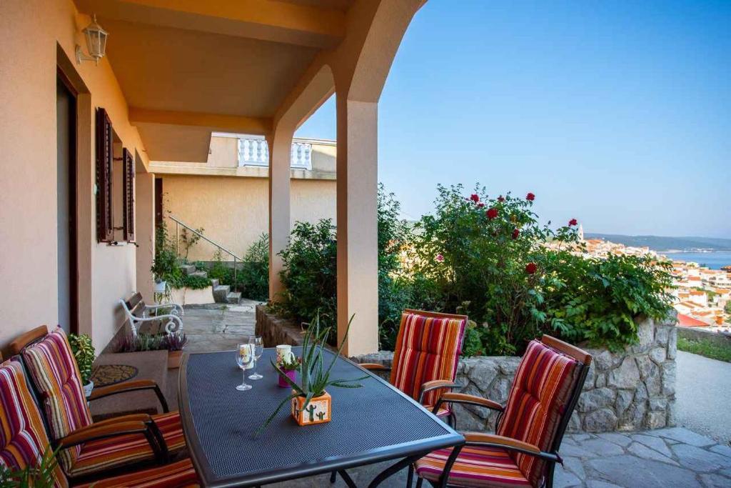 a table and chairs on a patio with a view at Apartment in Vrbnik/Insel Krk 36856 in Vrbnik