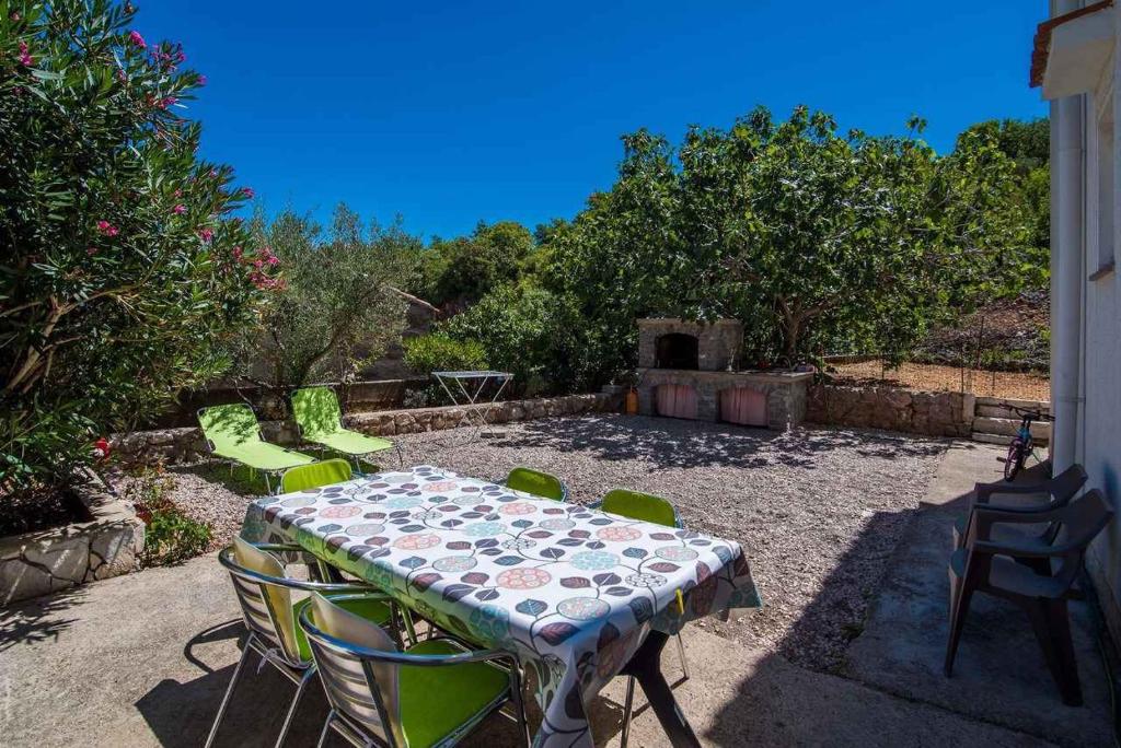 a patio with a table and chairs in a yard at Apartment in Vrbnik/Insel Krk 36842 in Vrbnik