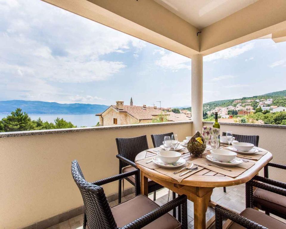 a table and chairs on a balcony with a view at Apartment in Vrbnik/Insel Krk 36858 in Vrbnik