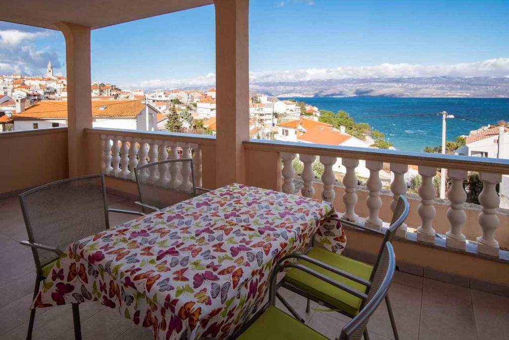 a table and chairs on a balcony with a view of the ocean at Apartments in Vrbnik/Insel Krk 36002 in Vrbnik