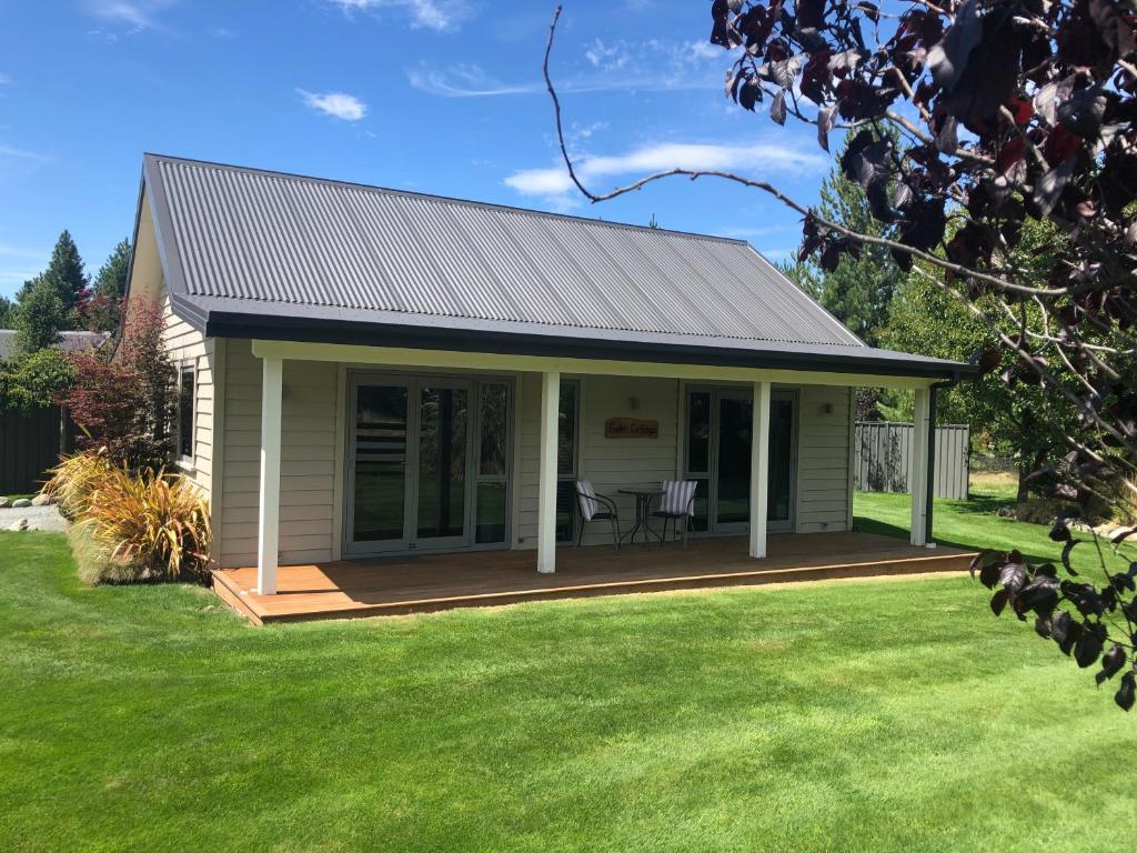 a small house with a porch and a deck at Foehn Cottage in Twizel