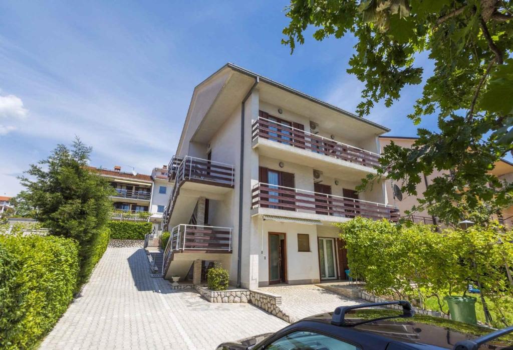 a house with a car parked in front of it at Apartments in Crikvenica 14113 in Crikvenica
