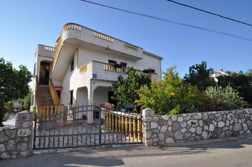 a large white house with a stone fence at Apartment in Vrbnik/Insel Krk 13613 in Vrbnik