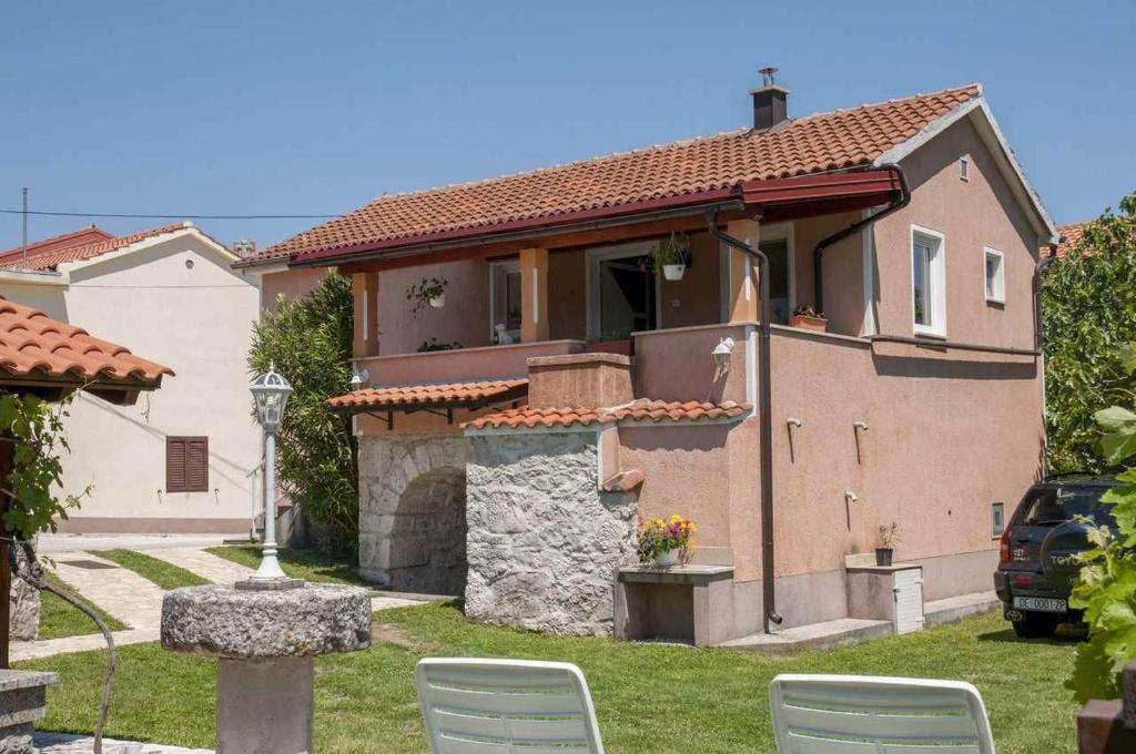 a house with two chairs in a yard at Apartment in Risika - Island Krk 35824 in Risika