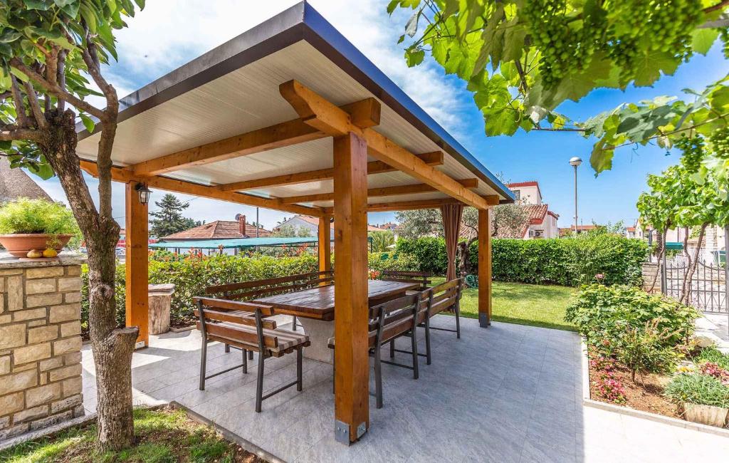 a wooden gazebo with a table and chairs at Apartments in Porec/Istrien 10281 in Poreč