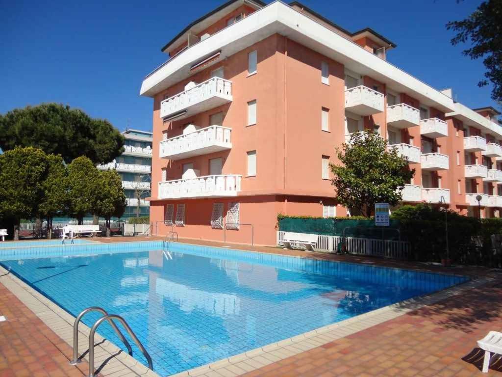 un edificio con piscina frente a un edificio en Apartment in Porto Santa Margherita 25143, en Porto Santa Margherita