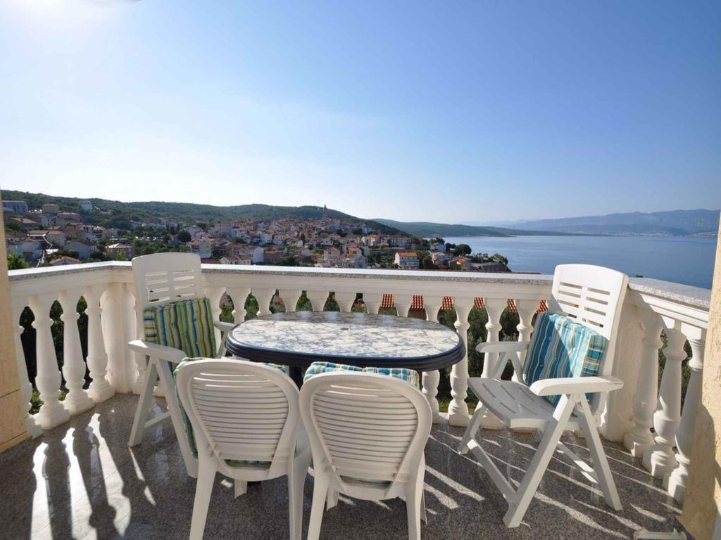 a table and chairs on a balcony with a view at Apartment in Vrbnik/Insel Krk 13603 in Vrbnik