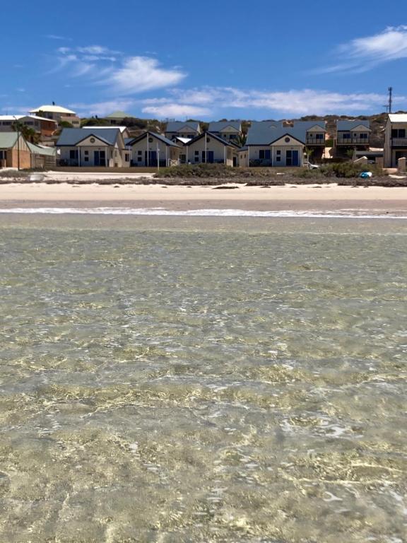 a body of water with houses in the background at Oceanside Village in Denham