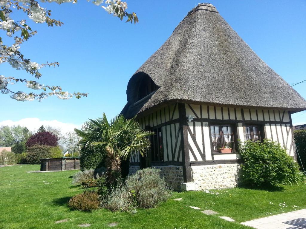 Cabaña con techo de paja en un jardín en Gites de la Ferme de l'Eglise, en Fatouville-Grestain