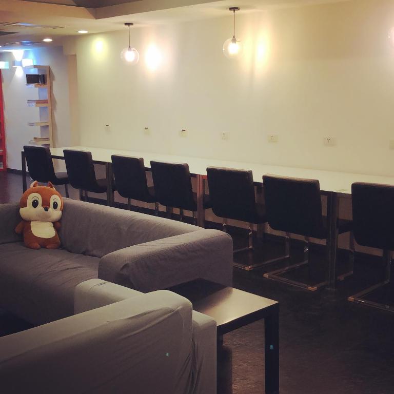 a waiting room with a couch and chairs at Single inn- KAOHSIUNG LINSEN in Kaohsiung