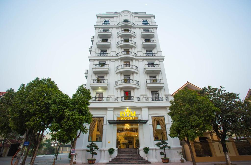 een groot wit gebouw met een trap ervoor bij BVM HOTEL in Ninh Binh