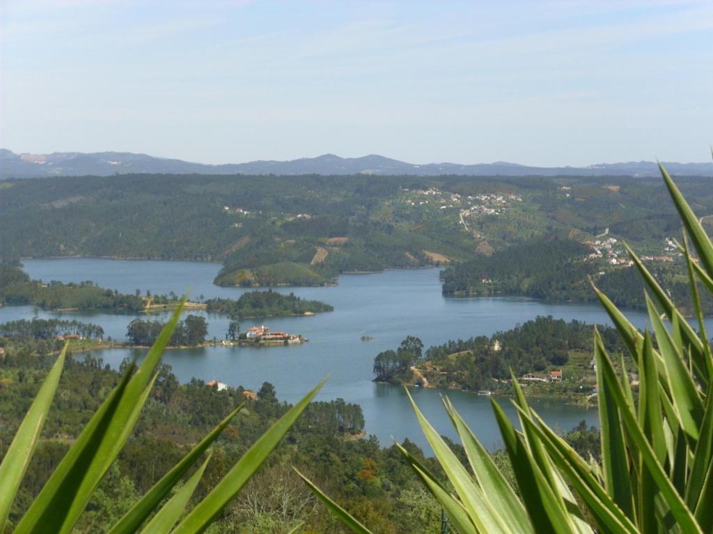 Blick auf einen See mit Bäumen und eine Stadt in der Unterkunft Casa do Trovador in Serra