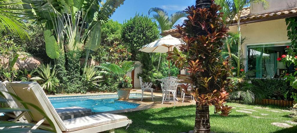 een achtertuin met een zwembad en een palmboom bij La Tropezina in Búzios