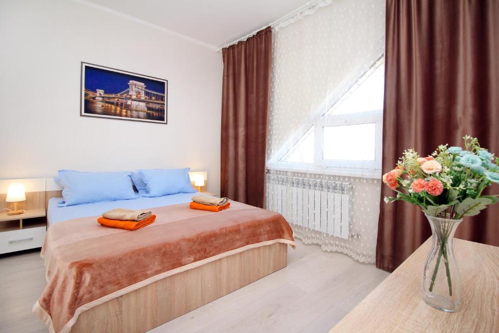 a bedroom with a bed and a vase of flowers at ЖК Радужный берег, апартаменты рядом с аэропортом РБ328 in (( Turksib ))