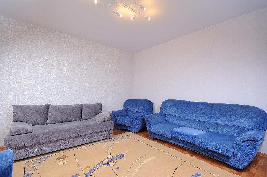 オムスクにあるOmskSutki Apartments on Volchovstroya st.のリビングルーム(青いソファ、青い椅子付)
