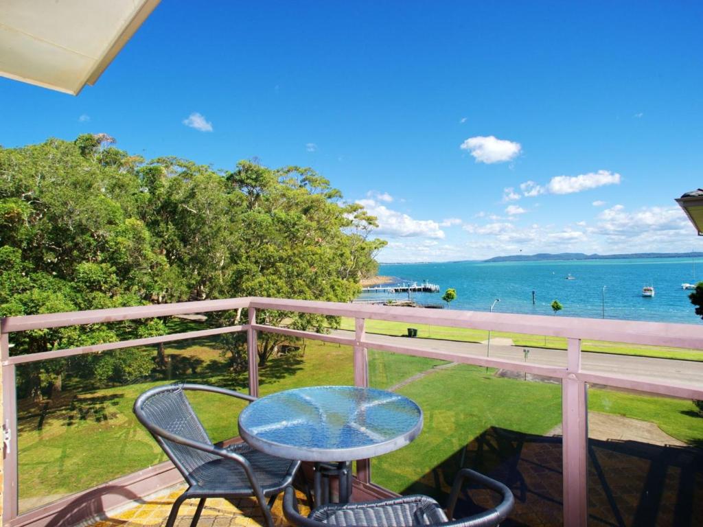 a table and chairs on a balcony with a view of the ocean at Collendina 15 19 Kurrawa Close water views and wifi in Nelson Bay