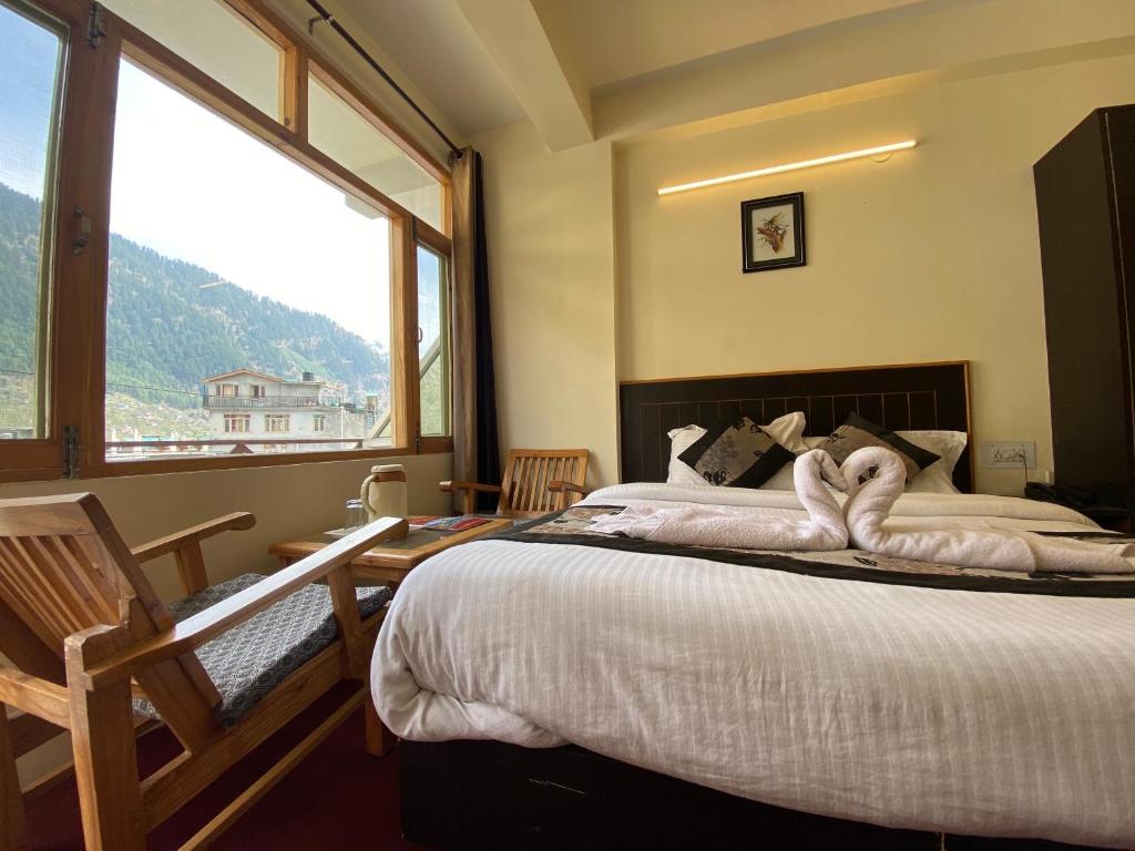 a bedroom with a bed and a large window at The Destination Manali in Manāli