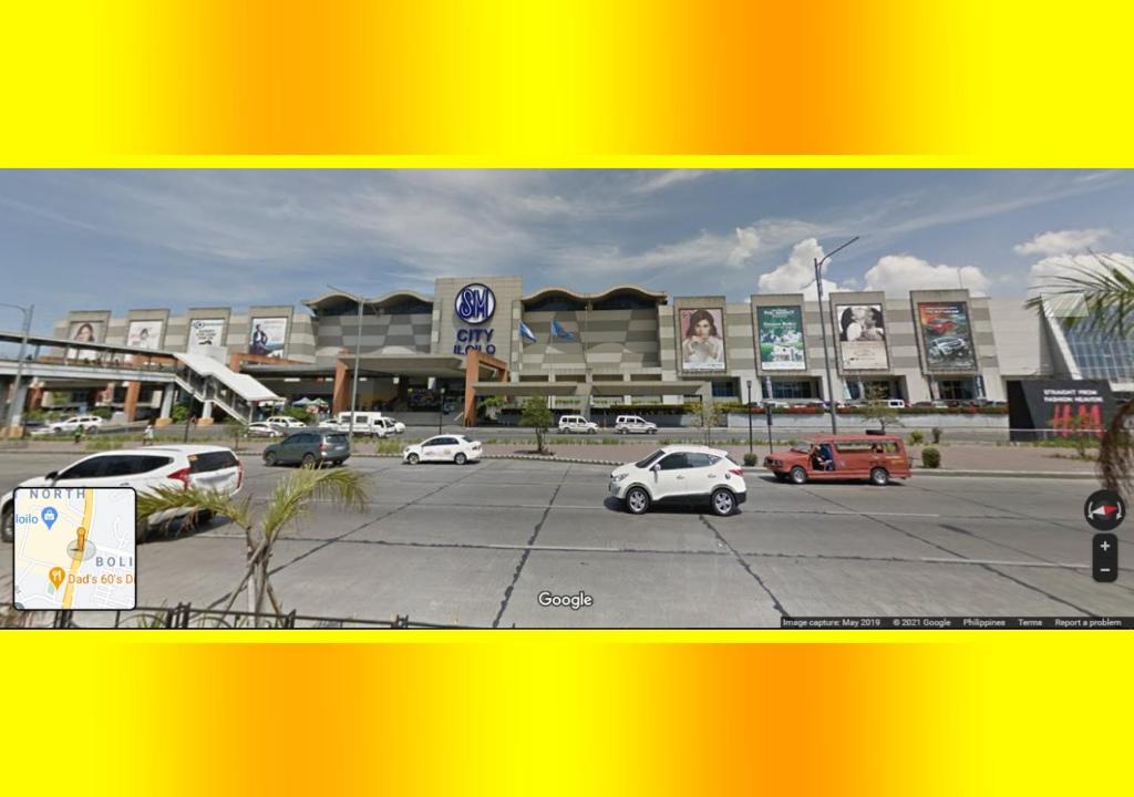 a parking lot with cars in front of a building at Megaworld Area Place with Fan 2 and WIFI in Iloilo City