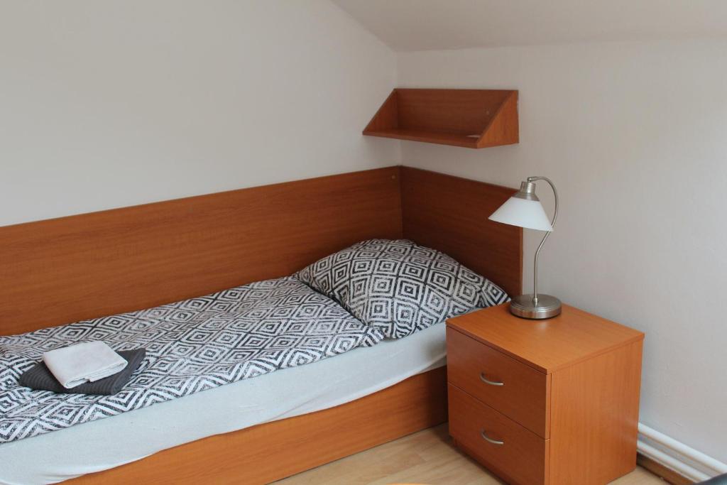 a bed with a wooden headboard and a night stand at Ubytování Na špejcharu, Želevčice in Slaný