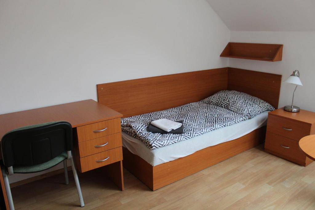 a small bedroom with a bed and a desk and a chair at Ubytování Na špejcharu, Želevčice in Slaný