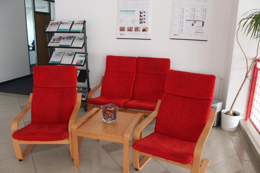 four red chairs and a table in a room at Ubytování Na špejcharu, Želevčice in Slaný