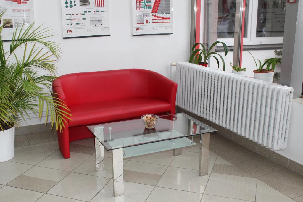 a red chair and a glass table in a room at Ubytování Na špejcharu, Želevčice in Slaný