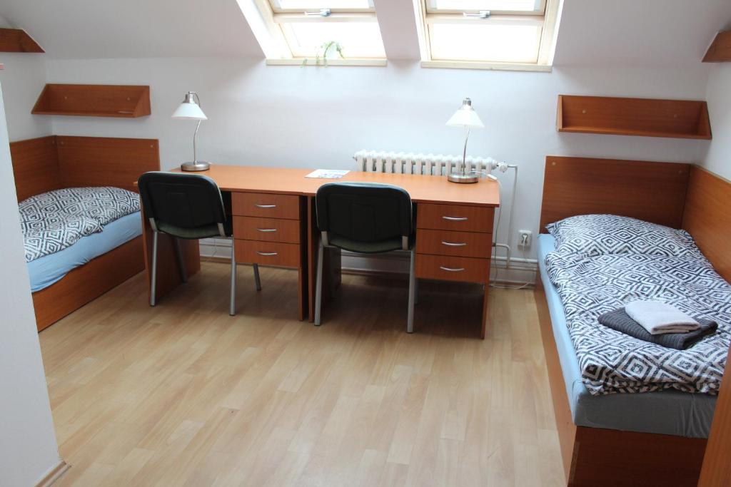 a room with a desk and a bed and a desk and chairs at Ubytování Na špejcharu, Želevčice in Slaný