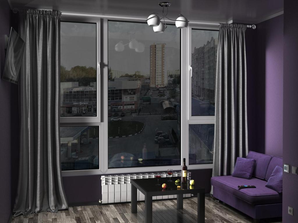 ブリャンスクにあるАпартаменты в центре на Авиационной 19の紫色のソファと大きな窓付きのリビングルーム