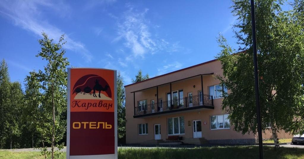 um prédio de apartamentos com uma placa em frente em Hotel Karavan em Petrozavodsk