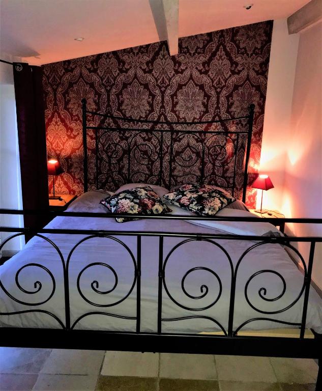 a bedroom with a bed with a black frame at B&amp;B La Buissonniere in Xhoris