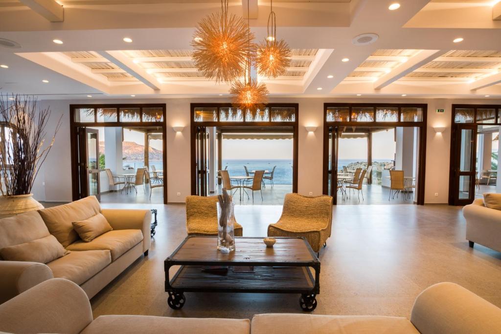 a living room with couches and a table at Aegean Village Beachfront Resort in Amoopi
