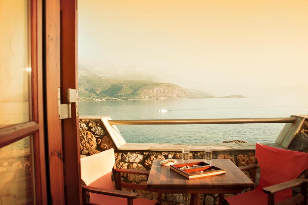 balcón con mesa y vistas al agua en Alkyoni Apartments, en Agios Nikolaos