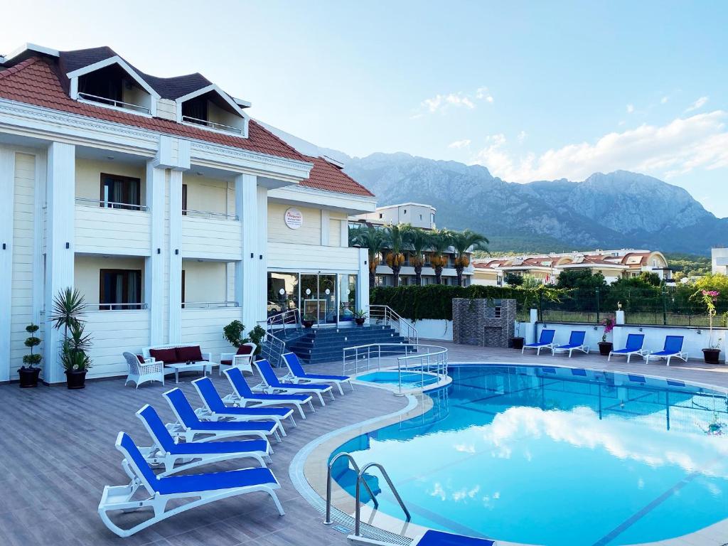 um hotel com espreguiçadeiras e uma piscina em Emily Rose Hotel em Kemer