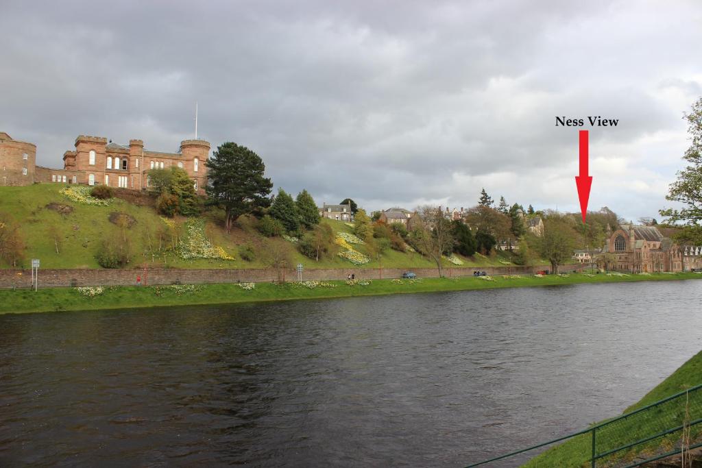 a view of a river in front of a castle at Ness View Apartment in Inverness
