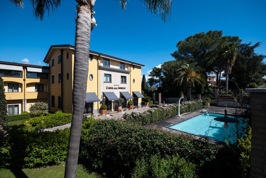 a hotel with a palm tree and a swimming pool at Hotel Casal Dell'Angelo in Marigliano